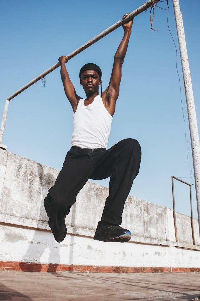 mężczyzna zawisający na metalowym drążku mężczyzna zawisający na metalowym drążku