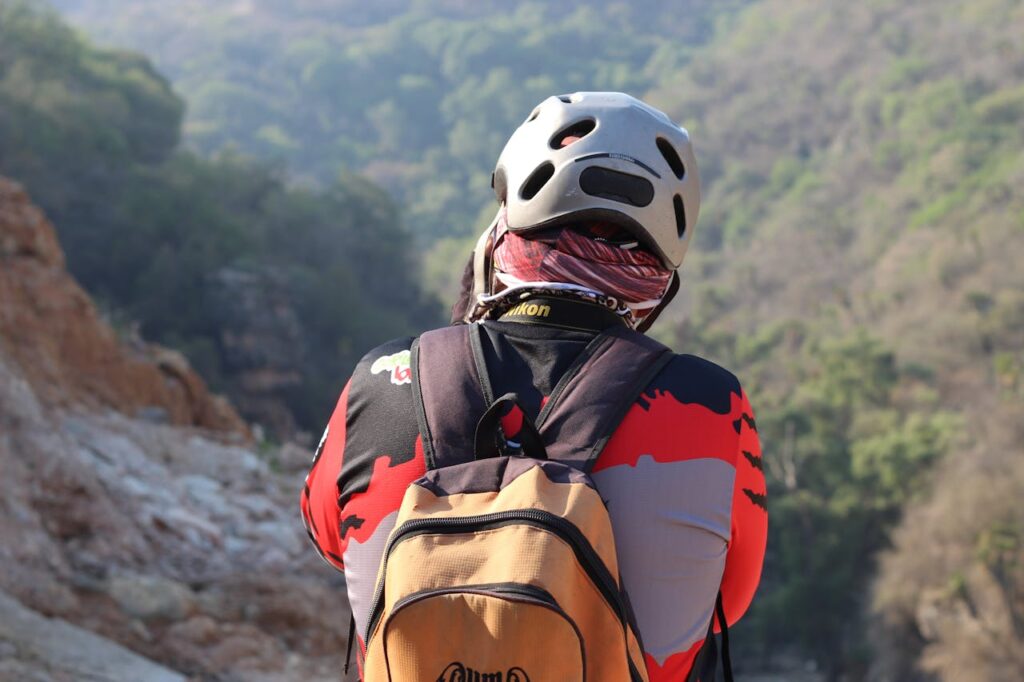 A mountain biker with a helmet and backpack exploring a scenic trail.